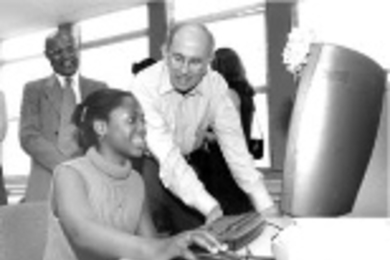 Alexander d'Arbeloff, chair of the MIT Corporation, works at a computer with Davina Griffith, a participant in SPES (Supplemental Program of Educational Skills), a nonprofit after-school program in Dorchester.