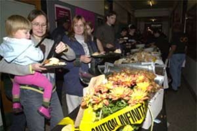 Architecture graduate student Dorothy Shamonsky holds Iris, 2, who looks interested in some taste-testing as they go through the food line at the Infinite Buffet. Iris' twin sister Lily and father Andy Bennet (not pictured) were also in attendance.