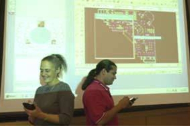 Team leaders Janice Klein and Feniosky Peï¿½a-Mora demonstrate use of personal digital assistants that will be key to a system for streamlining communications for virtual business meetings.