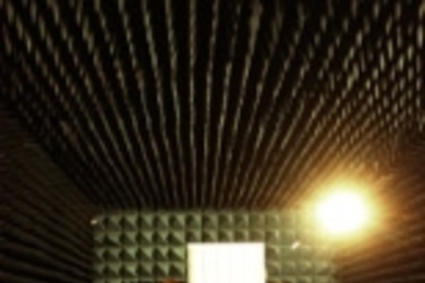 At Lincoln Lab's Advanced Electromagnetic Systems Antenna Test Range,        Alan Rogers (right) associate director and senior research scientist at        Haystack, works with scientist Kevin Kolodziejski of TruePosition Inc. in        a special chamber that dampens the echo of radio signals. They are testing a prototype cell phone antenna that measures the angle of arrival of the phone's signal,...