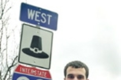 Yanni Tsipis stands next to the Massachusetts  turnpike sign at the Massachusetts Avenue ramp.
