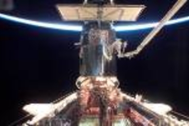 Michael Massimino working on the Hubble Space  Telescope from the end of Columbia's robotic arm. Massimino was the 10th  MIT graduate to perform an EVA (extravehicular activity).