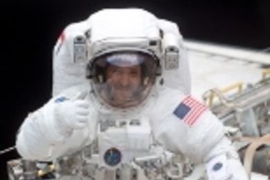 John Grunsfeld gives a thumbs up during an Extravehicular Activity, the 25th by  an MIT graduate.
