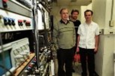 Bertrand Delgutte (left) and Andrew Oxenham (center), research scientists at the  Research Lab for Electronics, meet with graduate student Zachary Smith in the  lab.