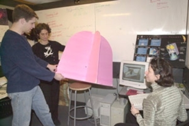 Paul Wooster (left), a senior in aero/astro, and graduate students Kalina        Galabova and Carole Joppin (far right) are building a prototype of a space capsule for launching mice into low-Earth orbit. The $5 million to $10 million project involves students interested in Mars travel at three universities.