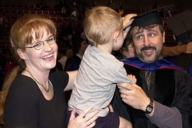 Yuri Ivanov gets his tassel turned (and hat swiped) by his three-year-old        son Sasha (held by his wife Sarah Wilkenson) just after receiving his Ph.D. in media arts and sciences.