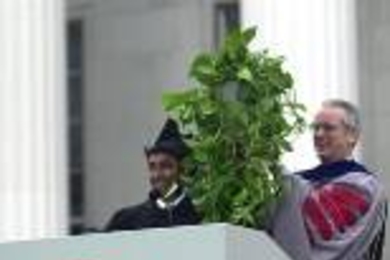 Senior class president Sudeb Dalai presents President Charles Vest with        a plant that a friend of his "borrowed" from Vest's office four years ago after hacking his way in.