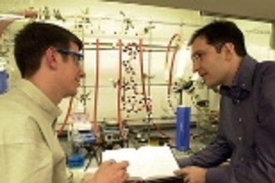 Graduate student Michael C. Hewitt, left, speaks with Professor Peter H.        Seeberger in the lab where their work on malaria has been taking place.