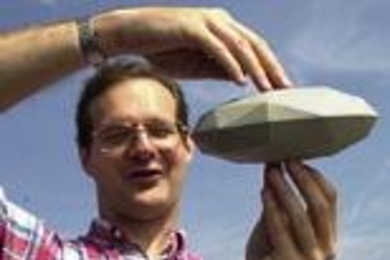 Researcher Stephen Slivan displays a model he made to explain the orientation of asteroids.