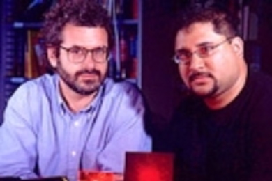 Media Lab professor Neil Gershenfeld, left, and MIT graduate Ravi  Pappu with an epoxy token made of tiny glass spheres that may improve digital  information security on the Internet and elsewhere.