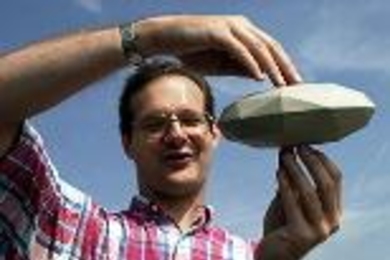 Researcher Steven Slivan displays a model he made to explain the orientation of asteroids.