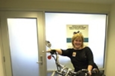 Kimberly Shooter, chief marketing officer for the MIT Federal Credit Union, tries out the Harley-Davidson motorcycle to be raffled.