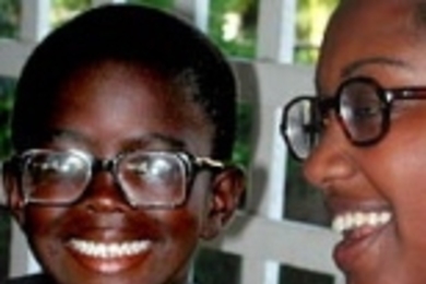 Senior Selam Daniel (right) of chemical engineering smiles after fitting a very nearsighted Guyanese boy with eyeglasses, his first pair ever.