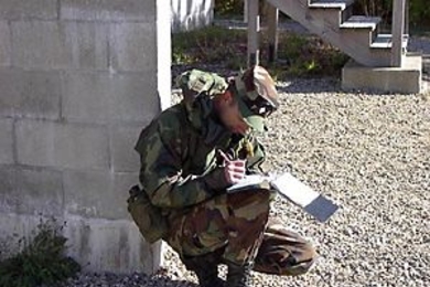 Cadet Battalion Commander Aneal Krishnan hunkers down to write an evaluation of a cadet's performance during fall field training exercises at Camp Edwards on Cape Cod.