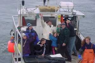 Mattie Thomson (center, in white jacket), skipper of the F/V Striker, took school children out on his fishing boat to teach them about marine ecology and a fisherman's life, as part of Adopt-a-Boat, a program coordinated by MIT Sea Grant.