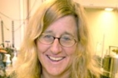 Professor Karen Gleason shows how water seeped in to conventional fabric, and beaded up like a marble on fabric treated with her new waterproofing technique.