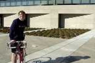 Cancer survivor Kyle Rattray stands next to his bike outside the Zesiger Center. He and a friend will be riding their bikes from Boston to Seattle this summer to raise money for the American Cancer Society.