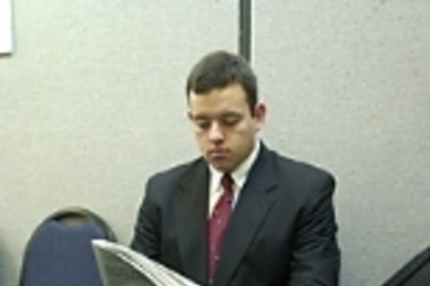 David Gutierrez, a senior in electrical engineering and computer science, reads a newspaper while waiting his turn for a job interview.