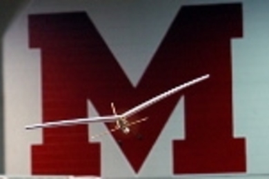 An egg-bearing model airplane soars in Johnson Athletic Center during aero/astro's unified aerial competition.