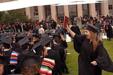 Nancy Ramirez waves her mechanical engineering degree triumphantly, much to the delight of the Ramirez family of Juana Diaz, Puerto Rico, and the audience on Killian Court.