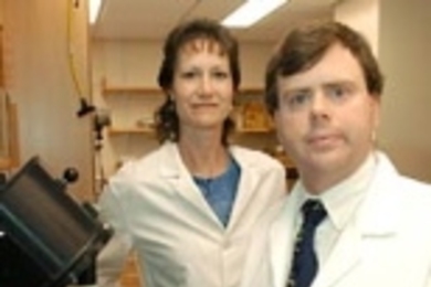Lincoln Lab/MIT biologists Martha Petrovick and Todd Rider with the centrifuge and luminometer used in the system they and their colleagues developed to improve detection of such pathogens as SARS and anthrax.