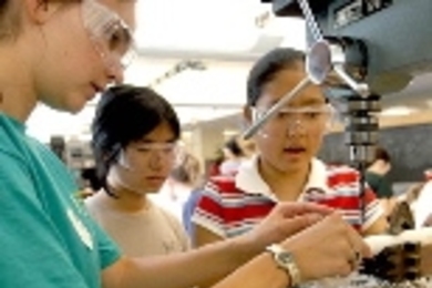 Joelle Brichard, a resident tutor and MIT student, assists Women's Technology Program high school students Helen Deng San Francisco, center, and Julia Chang of Torrance, Calif., as they build a part for a motor.