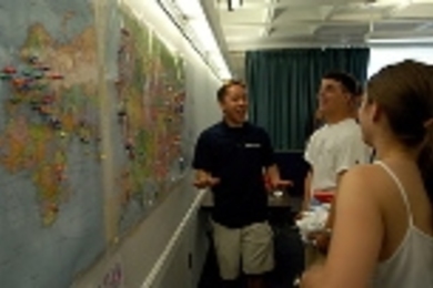Sophomore in mechanical engineering Jon Wu (left) shares a laugh with incoming freshmen Brian Schmidt and Laura Daher in front of the map on which freshmen were asked to put a tack to mark where they come from.