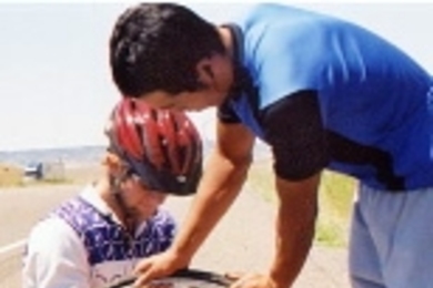 Taku, standing, helps Kyle attend to his second flat tire, just outside Billings, Mont.