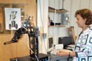 Una -May O'Reilly, co-principal investigator for MIT's newest robot, watches as Cardea lets itself out the door of the lab to go for a stroll down the hall.