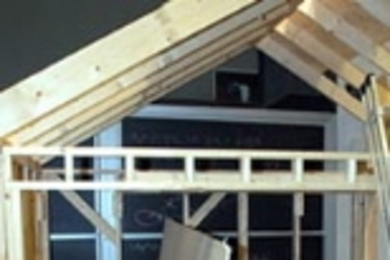 Dale Cotton, a junior in mechanical engineering, demonstrates the drywall/sheetrock lift and installation system designed and built by his team in 2.009 (Product Engineering Processes).