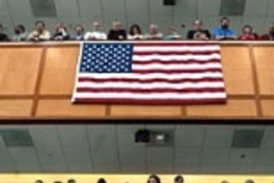 Lincoln Laboratory employees gaze down as U.S. Rep. John Tierney, flanked by Rep. Marty Meehan, left, and U.S. Sen. Edward Kennedy, speaks at a panel highlighting the regional collaboration between academic, military and private sectors.