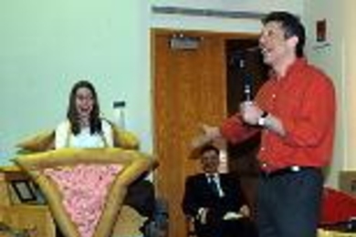 Professor Edward Farhi (right), who argued on behalf of latkes, jokingly derides hamentashen, represented at the debate in human form by Sophie Rapoport, a sophomore in mathematics. Seated behind them is emcee Donald Sadoway.