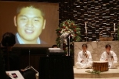 Members of Oori, MIT's Korean drum group, perform at the memorial service for Daniel Mun, as images of the 20-year-old student are projected onto a screen.