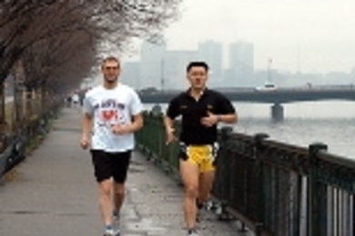Triathletes Ken Ross (left) and Harn Wei Kua train by the Charles. Ross posted a time of 3:13 in the Boston Marathon.