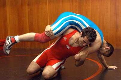 Mathematics graduate student Nate Ackerman, in red, trains with colleague Vadzim Fliaha at MIT. Ackerman holds dual citizenship in the USA and Great Britain, and will wrestle for Great Britain in the summer 2004 Olympics in Athens. <a onclick="MM_openBrWindow('olymp-wrestler-enlarged.html','','width=509, height=583')">
<span onmouseover="this.className='cursorChange';">Open image gallery</span>
</...