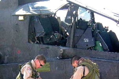 Prior to evening patrol in Iraq, AH-64 Apache pilots don survival gear after being instrumented.