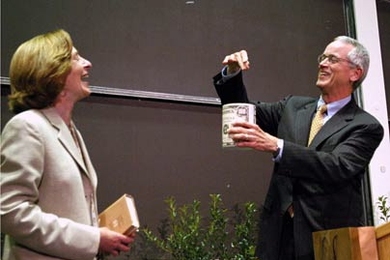 Noting that a provost recognizes the "value of resources," Charles Vest, the 15th president of MIT, hands the 16th president, Susan Hockfield, a can of shredded money. Dr. Hockfield is currently the provost of Yale.