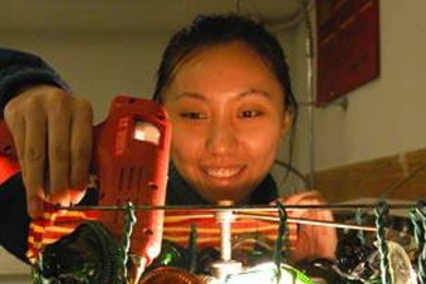 Rene Chen, a sophomore in materials science and engineering, makes an intriguing lamp out of jagged jar bottoms as she "up-cycles" trash into art.