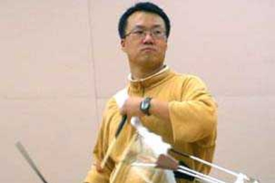 Sung-Hee Do plays a traditional Korean instrument called a "Jang-go" at Oori practice.