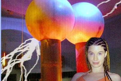 "Zap!" composer Christine Southworth (S.B. 2002) poses with the Van de Graaff generator that provides static and flashing lights for her musical composition. "Zap!" is a seven-part piece featuring the former atom-smasher in concert with flutes, guitar, cello, bass, piano, robots and human voices.