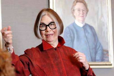 Adele Santos addresses the MIT Women's League on Feb. 18. In the background is a portrait of former MIT First Lady Priscilla Gray.