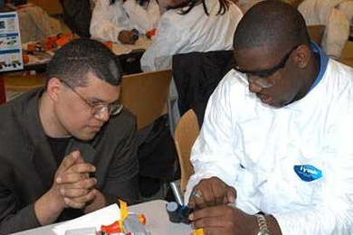 Christopher Banks of Baton Rouge, La., right, examines the workings of a disposable camera under the watchful eye of mechanical engineering Professor Martin Culpepper, during a 'Take-Apart Learning' workshop for high school students held March 24. The workshop was part of "Engineering at MIT is Fun Day," an event hosted in association with the National Society of Black Engineers convention.