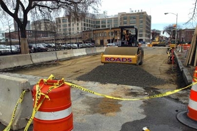 Workers begin paving a section of Massachusetts Avenue between Vassar and Albany streets on Friday, April 8.