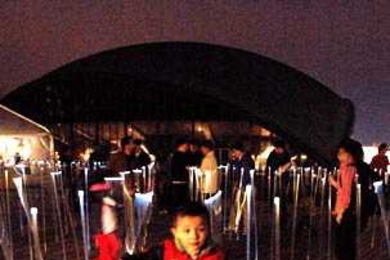 'White Noise/White Light' lights up May 2 as Yi Fan runs through the exhibit Monday evening on Kresge Oval. The boy's father is a Sloan professor visiting from Beijing.
