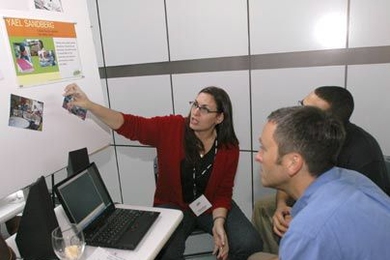 Yael Sandberg of Brazil, a participant in the IDEAS Institute for Innovative Design Experiences After School, shared information about her project at a June 28 event at the MIT Media Lab. Amon Millner (hidden), a grad student at the MIT Media Lab, and Tony Streit, director of the YouthLearn Initiative at the Educational Development Center in Newton, listen.