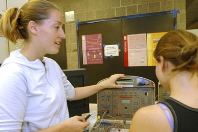 Laura Waller, an MIT doctoral candidate in electrical engineering, discusses how to make a metal detector with one of the high school girls participating in this summer's Women's Technology Program.