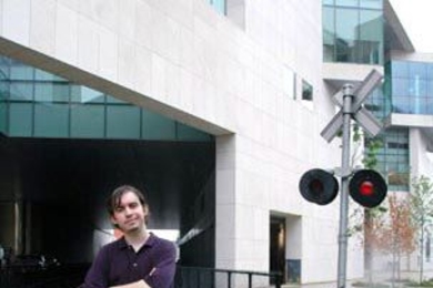 Freshman Anthony Rizos stands on the tracks by MIT's new brain and cognitive sciences complex earlier this month. Rizos turned his love of trains into a job at Amtrak.
