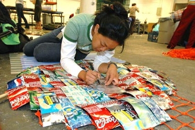 MiHae Chang, a junior in architecture, puts the finishing touches on the can doorway of her team's portable homeless shelter. Working in teams of four or five, students had five days to design and build the individual shelters for Professor Jan Wampler's architecture class.