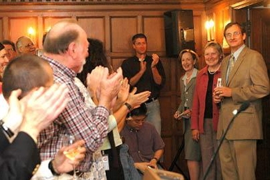 New Nobel laureate Richard R. Schrock, right, enters a press conference to a standing ovation on Oct. 5 at MIT. To his right is his wife, Nancy F. Carlson (in pink), and MIT President Susan Hockfield.