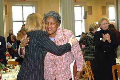 Donna Brazile embraces MIT President Susan Hockfield at the Martin Luther King Jr. breakfast.
